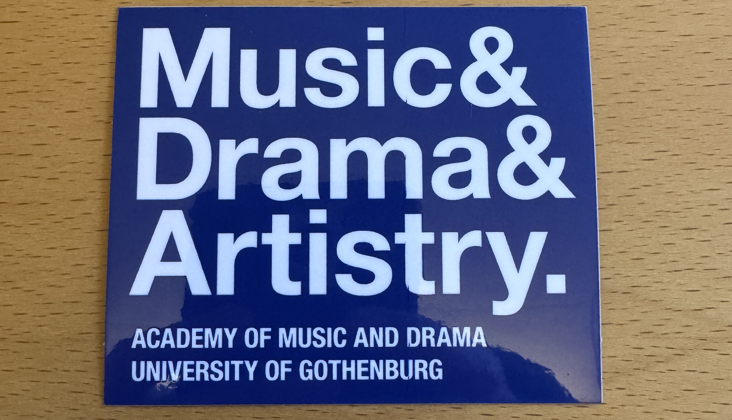 Ett klistermärke med texten "Music & Drama & Artistry"