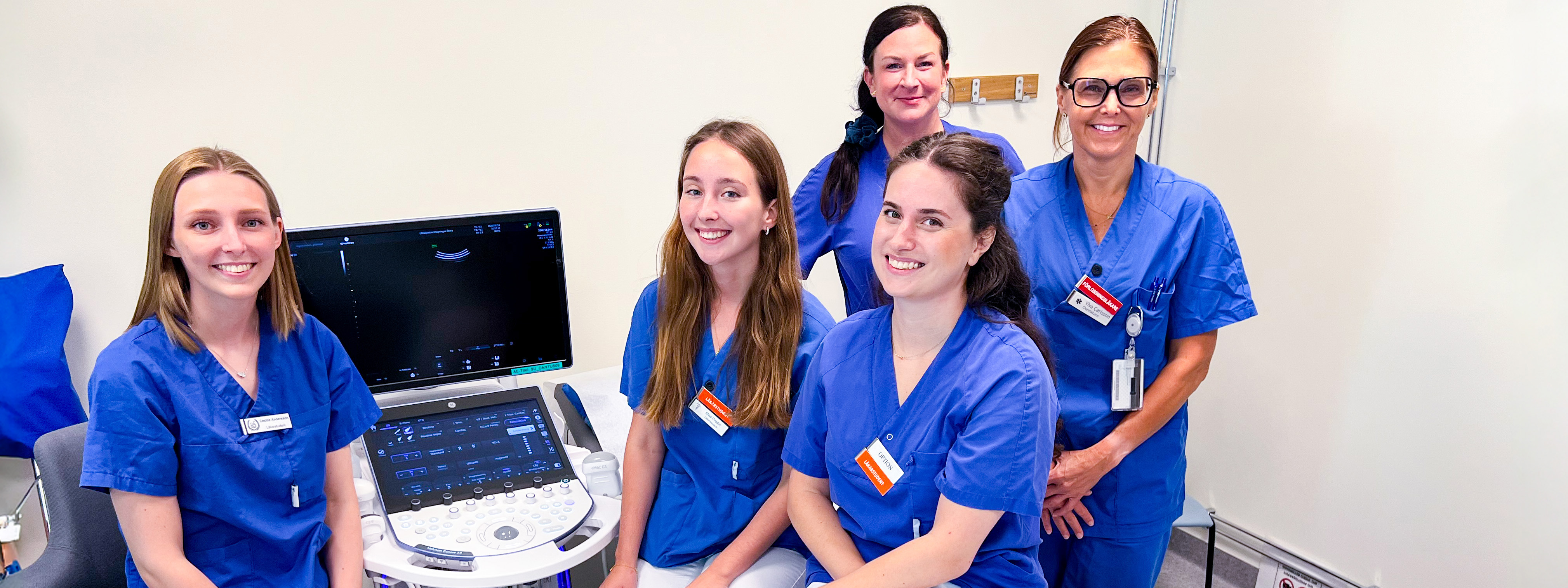 Five people in an ultrasound examination room.