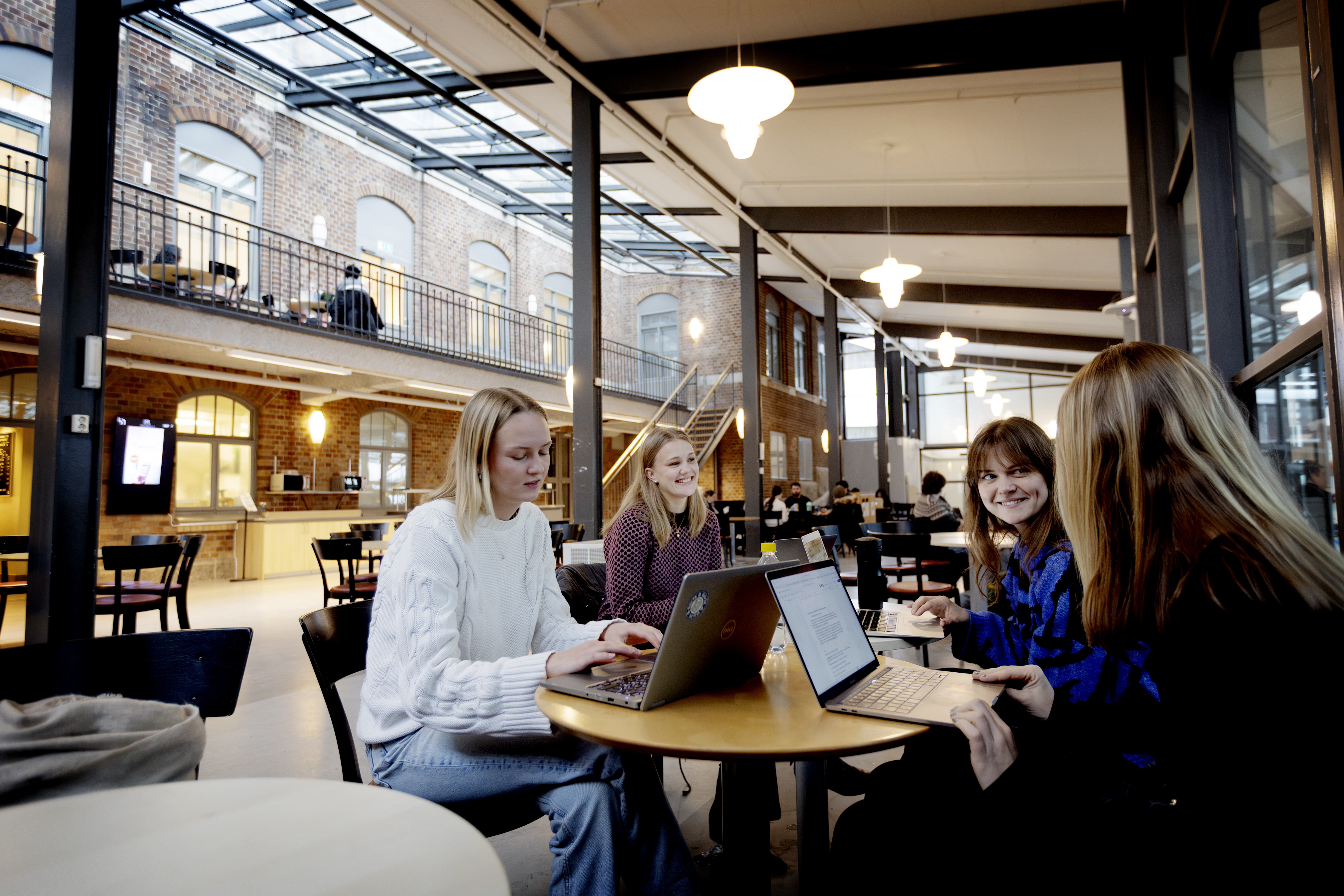 Glada studenter sitter och pratar i caféet på Hälsovetarbacken.