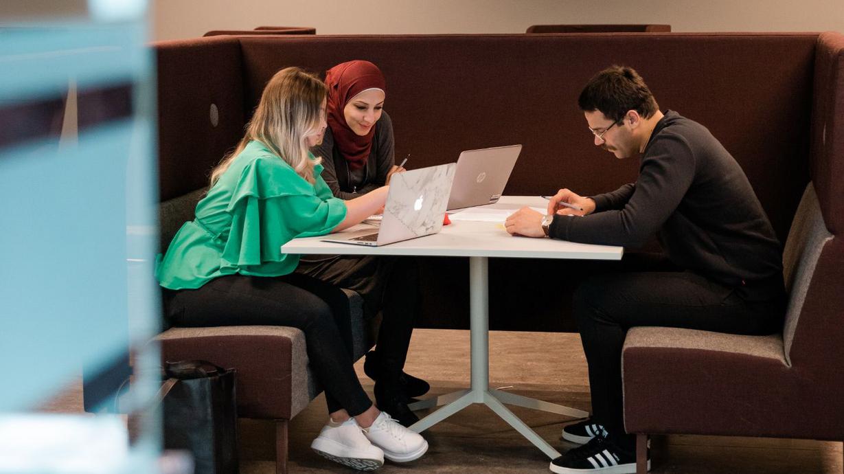 Studenter med datorer i b-huset på Pedagogen