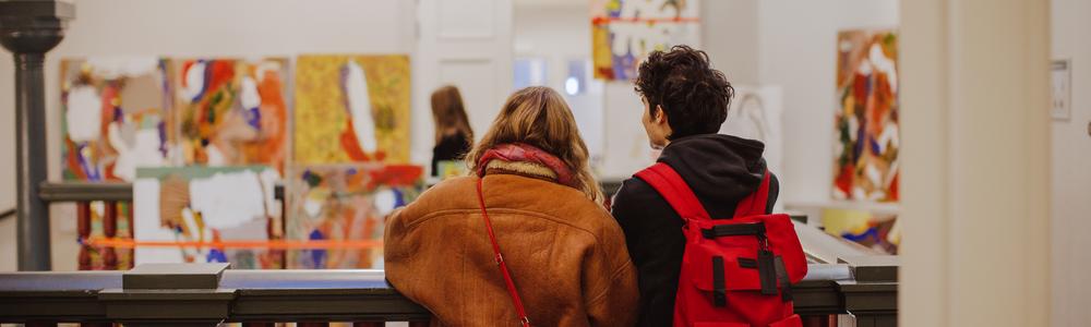 Studenter som tittar på konst i trapphuset på Valand