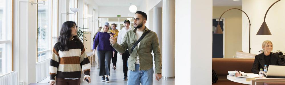 en grupp studenter går i en korridor på Handelshögskolan