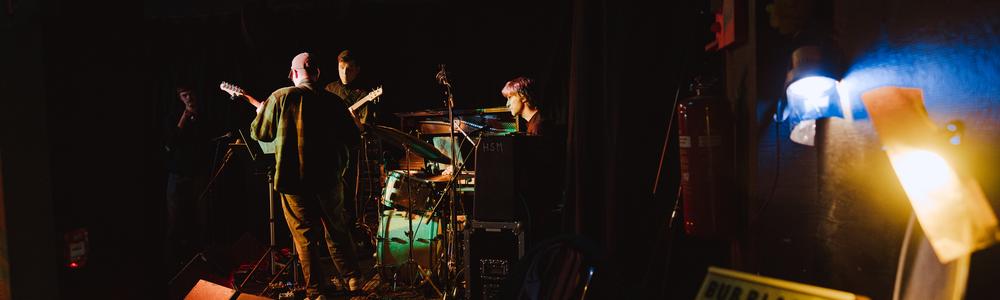 Improvisation students, a guitarist, a bassist and a drummer on stage at ‘Bubblan’, spring 2025.