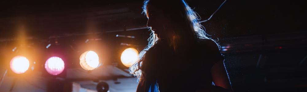 Student backlit by stage lighting