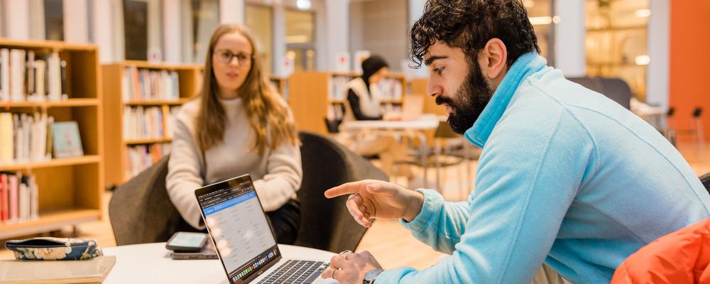 A student is sitting next to a computer studying