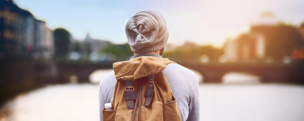 Young man with a rucksack on a bridge