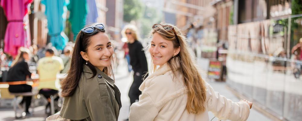 två kvinnor med går med cykel på gatan