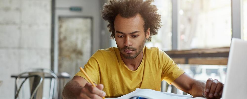 En nedstämd student sitter vid ett skrivbord.
