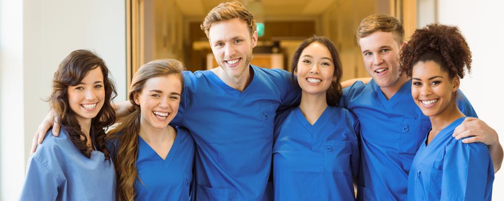Grupp med glada unga sjuksköterskestudenter