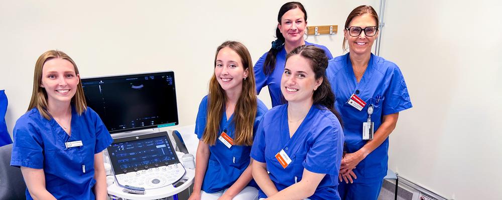 Five people in an ultrasound examination room.