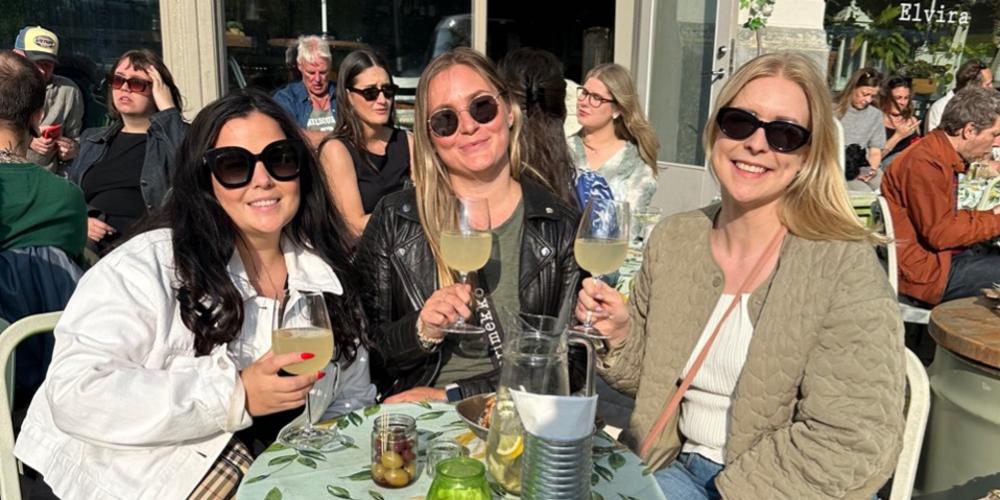 tre kvinnor på en uteservering i solen