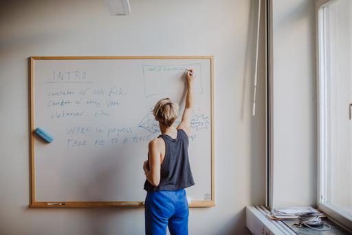 Student som arbetar med text på en whiteboardtavla