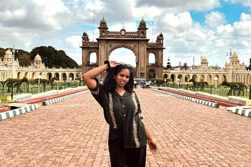 Kvinna framför palats i Indien.