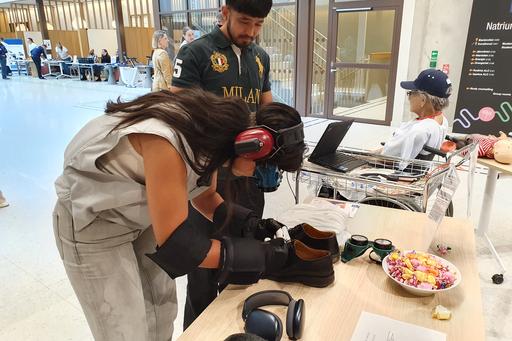 Internationella besökare testar utrustning för att simulera hur det känns att åldras.