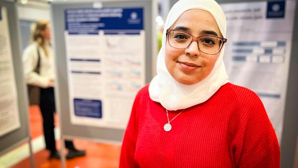 Läkarstudenten Hifaa framför posterutställningen.